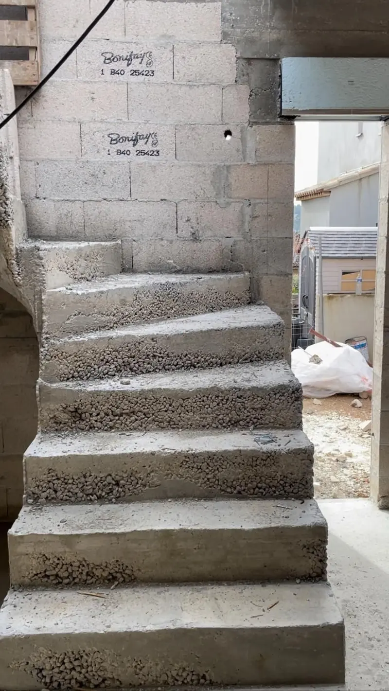 Escalier en béton coulé en place dans une maison en blocs