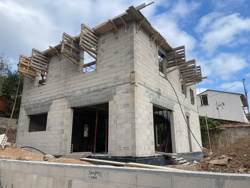 Maison en blocs béton en cours d'élévation avec coffrages des linteaux
