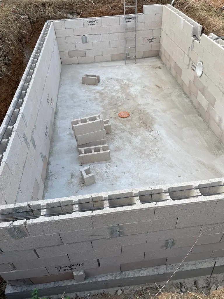 Bassin de piscine monté en blocs à bancher sur radier béton