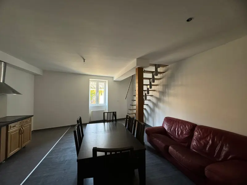 Pièce à vivre rénovée avec table à manger et escalier en bois