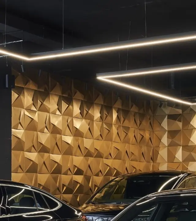 Mur décoratif doré en relief géométrique éclairé par des lignes LED